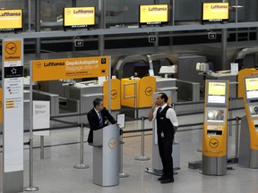 Lufthansa employees wait for customers at the airport in Munich, southern Germany, Tuesday, Dec. 2, 2014.