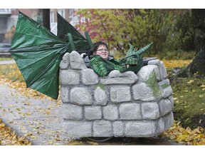 Emile Laliberte poses in his Halloween costume in Montreal, Sunday, October 28, 2018. In Halloweens past, 10-year-old Emile struggled to find costumes that wouldn't be hidden by his wheelchair.But Laliberte looks to be the envy of all the children on his block as he sets out trick or treating on Oct. 31 as a green dragon with 3D-printed scales, motorized wings and glowing animated eyes to watch over the Styrofoam castle that surrounds his wheelchair.THE CANADIAN PRESS/Graham Hughes