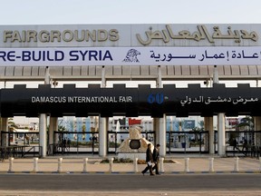 In this Tuesday, Oct. 2, 2018 photo, Chinese visitors arrive to the opening of the Syria rebuilding exhibition at the fair grounds in Damascus, Syria. With back-to-back trade fairs held in Damascus this month, Syria hopes to jumpstart reconstruction of its devastated cities by inviting international investors to take part in lucrative opportunities.