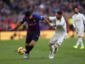 Barcelona forward Luis Suarez, left, and Real defender Sergio Ramos fight for the ball during the Spanish La Liga soccer match between FC Barcelona and Real Madrid at the Camp Nou stadium in Barcelona, Spain, Sunday, Oct. 28, 2018.