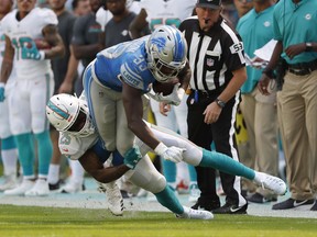 Miami Dolphins cornerback Xavien Howard (25) tackles Detroit Lions running back Kerryon Johnson (33), during the first half of an NFL football game, Sunday, Oct. 21, 2018, in Miami Gardens, Fla.