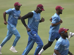 West Indies' cricket captain Jason Holder, center, along with teammates warmup during a practice session ahead of their second test match against India in Hyderabad, India, Thursday, Oct. 11, 2018.