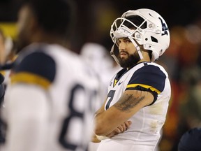 West Virginia quarterback Will Grier watches from the bench during the second half of an NCAA college football game against Iowa State, Saturday, Oct. 13, 2018, in Ames, Iowa.