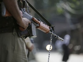 FILE- In this Aug.14, 2018 file photo, an Indian paramilitary soldier stands guard during a search operation in Srinagar, Indian controlled Kashmir. Police say government forces have killed at least two rebels during a gunbattle that sparked violent anti-India protests by residents in disputed Kashmir.