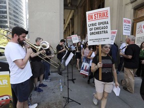 Jeremy Mueller, left, and other striking Lyric Opera musicians perform as their colleagues picket outside The Civic Opera House in Chicago on Tuesday, Oct. 9, 2018.