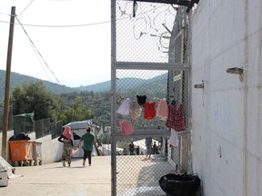 Women walk through the Moria refugee camp in Lesbos, Greece, Friday, Oct. 12, 2018.