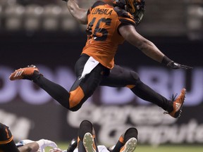 BC Lions fullback Rolly Lumbala (46) jumps over Toronto Argonauts wide receiver Duron Carter (89) after being tackled by BC Lions running back Wayne Moore (33) during CFL football action in Vancouver on Saturday, Oct. 6, 2018.