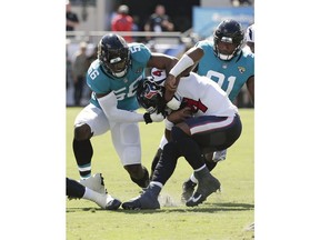 Jacksonville Jaguars defensive end Dante Fowler, left, and defensive end Yannick Ngakoue, right, sack Houston Texans quarterback Deshaun Watson, center, during the first half of an NFL football game, Sunday, Oct. 21, 2018, in Jacksonville, Fla.