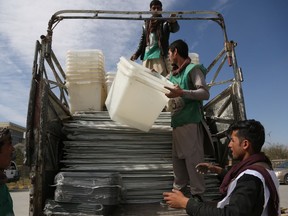 In this Wednesday Oct. 17, 2018, photo, Afghan election workers load ballot boxes and other election materials on a truck ahead of parliamentary elections, in Kabul, Afghanistan. Afghans will go to the polls on Saturday, hoping to bring change to a corrupt government that has lost nearly half the country to the Taliban. More than 50,000 security forces will be deployed to defend polling stations.