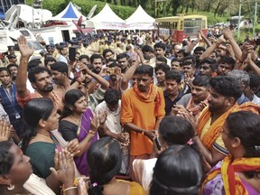 Protestors who are opposed to allowing women of menstruating age from entering the Sabarimala temple chant devotional hymns as they gather at Nilackal, a base camp on way to the mountain shrine in Kerala, India, Wednesday, Oct. 17, 2018. The historic mountain shrine, one of the largest Hindu pilgrimage centers in the world is set to open its doors to females of menstruating age following a ruling by the country's top court. Police arrested some protesters when they tried to block the path of some females. (AP Photo)