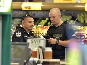 Members of the Louisville Metro Police Department talk inside a Kroger grocery in Jeffersontown, Ky., following a shooting that left two people dead, Wednesday, Oct. 24, 2018.