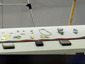 This photo from video provided by the Los Angeles Police Department shows some of the items recovered after the arrests of four people police say targeted celebrity homes for burglary, including those of Rihanna, Christina Milian, Los Angeles Dodgers baseball star Yasiel Puig and Los Angeles Rams NFL football wide receiver Robert Woods, at a news conference in Los Angeles, Tuesday, Oct. 2, 2018. Items they believe were stolen included expensive watches, handbags, jewelry and cellphones. (Los Angeles Police Department via AP)
