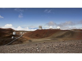 FILE - This Aug. 31, 2015, file photo shows telescopes on the summit of Mauna Kea on Hawaii's Big Island. Hawaii's Supreme Court upheld a decision to grant a construction permit for an embattled, international giant telescope project planned for a mountain Native Hawaiians consider sacred. The court ruling Tuesday, Oct.. 30, 2018, is a victory for the contentious Thirty Meter Telescope planned for Hawaii's tallest mountain, Mauna Kea.