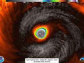 This false-color satellite image provided by the National Oceanic and Atmospheric Administration (NOAA) shows the moment the eye of Super Typhoon Yutu passed over Tinian, one of three main islands in the U.S. Commonwealth of the Northern Mariana Islands, producing damaging winds and high surf Wednesday, Oct. 24, 2018. The National Weather Service in Honolulu says maximum sustained winds of 180 mph (290 kph) were recorded around the eye of the storm, which passed over Tinian island and Saipan early Thursday morning local time. Waves of 25 to 40 feet (6 to 12 meters) are expected around the eye of the storm.