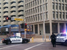 FILE - In this Dec. 11, 2015 file photo, police gather outside of City Hall while searching for a gunman in Albuquerque, N.M. Albuquerque police on Thursday, Oct. 18, 2018, announced the hiring of a law enforcement veteran to manage a unit for dispatchers and real-time crime analysts who was accused decades ago in a lawsuit of using excessive force during a traffic stop.