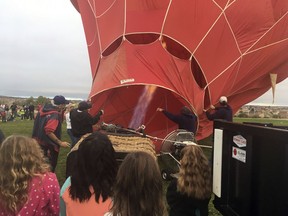 FILE - Oct. 6, 2017 file photo a crew from the upcoming Albuquerque International Balloon Fiesta inflate their balloon for students at Enchanted Hills Elementary School in Rio Rancho, N.M. The 47th Albuquerque International Balloon Fiesta is set to start Saturday, Oct. 6, 2018, and will feature nearly 600 hot air balloons. The event is expected to draw around million visitors to central New Mexico but comes as Albuquerque continues to struggle with crime.