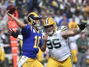Los Angeles Rams quarterback Jared Goff, left, throws a pass under pressure from Green Bay Packers defensive tackle Tyler Lancaster during the first half of an NFL football game, Sunday, Oct. 28, 2018, in Los Angeles.