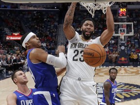 New Orleans Pelicans forward Anthony Davis (23) slam dunk over Los Angeles Clippers forward Tobias Harris and forward Danilo Gallinari, left, in the first half of an NBA basketball game in New Orleans, Tuesday, Oct. 23, 2018.