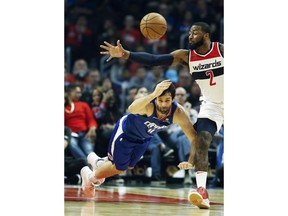 Los Angeles Clippers guard Milos Teodosic, left, of Serbia, tips the ball away from Washington Wizards guard John Wall, right, during the first half of an NBA basketball game in Los Angeles, Sunday, Oct. 28, 2018.
