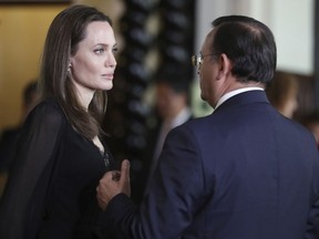 Hollywood actress Angelina Jolie listens to Peru's Foreign Minister Nestor Popolizio, after a press conference at the government palace in Lima, Peru, Tuesday, Oct. 23, 2018. Jolie, who met with Venezuelans refugees on Monday, is in Peru as a special envoy for the UN's High Commissioner for Refugees.
