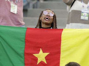 FILE - In this Sunday, June 25, 2017 file photo, a Cameroon fan holds a flag prior to the Confederations Cup, Group B soccer match between Germany and Cameroon, at the Fisht Stadium in Sochi, Russia. The head of the African soccer confederation says the body has "never thought" of removing Cameroon as host of next year's African Cup of Nations, a statement at odds with its position last week when it declined to back the country until at least two more inspection visits. Confederation of African Football president Ahmad, who goes by one name, said Tuesday, Oct. 2, 2018 the tournament "depends on Cameroon not CAF."