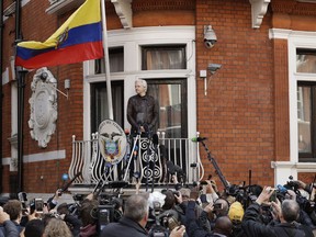 FILE - In this file photo dated Friday May 19, 2017, watched by the media WikiLeaks founder Julian Assange looks out from the balcony of the Ecuadorian embassy prior to speaking, in London.  Newly released Ecuadorean government documents made public late Tuesday Oct. 16, 2018, by Ecuadorean opposition lawmaker Paola Vintimilla, have laid bare an unorthodox attempt to extricate the WikiLeaks founder from his embassy hideaway in London by naming him as a political counselor to the country's embassy in Moscow.