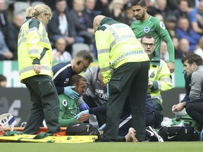 Brighton & Hove Albion's Glenn Murray receives treatment for an injury, before being carried off the pitch, during the match against Newcastle during their English Premier League soccer match at St James' Park in Newcastle, England, Saturday Oct. 20, 2018.