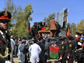 Guards of honor carry the coffin of Gen. Abdul Raziq, Kandahar police chief, who was killed by a guard, during his burial ceremony in Kandahar, Afghanistan, Friday, Oct. 19, 2018. Afghanistan's election commission on Friday postponed elections in Kandahar for a week, following a brazen attack on a high-profile security meeting there with a U.S. delegation that killed at least two senior provincial officials, including the province's police chief.