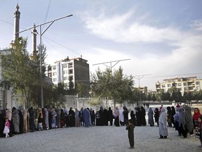 Women line up to vote at during the second day of Parliamentary elections in Kabul, Afghanistan, Sunday, Oct. 21, 2018. The elections were extended into a second day after delays caused by violence and technical issues.