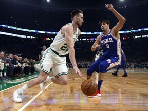 Boston Celtics' Gordon Hayward (20) drives past Philadelphia 76ers' Dario Saric (9) during the first half of an NBA basketball game in Boston, Tuesday, Oct 16, 2018.