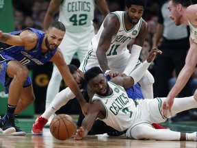 Boston Celtics' Jaylen Brown (7) battles Orlando Magic's Evan Fournier (10) for the ball during the first half of an NBA basketball game in Boston, Monday, Oct. 22, 2018.