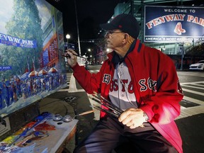 Artist Kevin Shea works on a painting outside Fenway Park in Boston, Monday, Oct. 29, 2018. The Boston Red Sox are due back at the park Monday evening after winning the 2018 World Series baseball championship against the Los Angeles Dodgers on Sunday in Los Angeles.