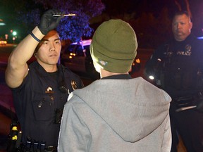 In this Saturday, Nov. 19, 2016 photo, Fullerton police conduct a field sobriety test on driver suspected of driving while impaired by marijuana in Fullerton, Calif.