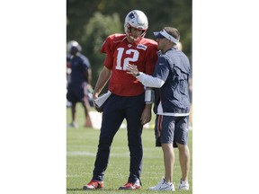 New England Patriots quarterback Tom Brady, left, speaks with offensive coordinator Josh McDaniels, right, during NFL football practice, Wednesday, Oct. 10, 2018, in Foxborough, Mass.