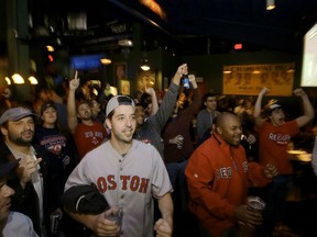 Boston Red Sox fan Eli Hoffman, of Boston, center left, reacts with others while watching a televised World Series baseball game in a bar, in Boston, Sunday, Oct. 28, 2018, as the Boston Red Sox play the Los Angeles Dodgers, in Los Angeles.