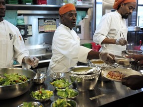 In this Tuesday, Oct. 2, 2018 photo, Phillip Oliver, of New Bedford, Mass., center, in recovery from opioid addiction, helps serve a meal in a culinary training program at the New England Center for Arts and Technology, in Boston. In Massachusetts, with Medicaid expansion already paying for opioid addiction treatment, emergency money from Congress goes largely toward recovery services. The state has chosen to use its federal money for those in long term recovery to pay for things like housing, and job training.