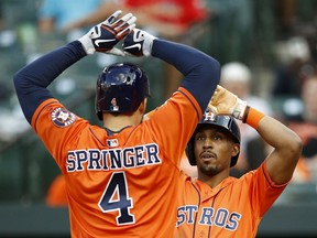 Houston Astros' Tony Kemp, right, high-fives teammate George Springer after scoring on Springer's two-run home run in the sixth inning of the first baseball game of a doubleheader against the Baltimore Orioles, Saturday, Sept. 29, 2018, in Baltimore.