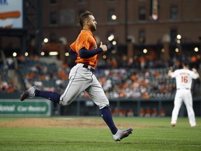 Houston Astros' George Springer scores a run on Carlos Correa's double in the ninth inning of the first baseball game of a doubleheader against the Baltimore Orioles, Saturday, Sept. 29, 2018, in Baltimore. Houston won 4-3.