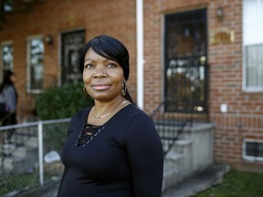 In this Tuesday, Oct. 17, 2018 photo, Octavia Mason poses for a photo outside of her mother's home in Baltimore. Mason's drug use after a broken marriage caused her to lose her license to teach high schoolers to become pharmacy technicians. Now she participates in a program called "Turnaround Tuesday" that helps people with criminal records, struggles with drug addiction, or simply a life of poverty find a living wage job.