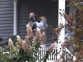 A person in a hazmat suit appears to be handling a letter that is enclosed in a plastic bag in Bangor, Maine, Monday, Oct. 15, 2018. A hazardous materials team was called Monday to investigate a suspicious letter sent to the home of Republican Sen. Susan Collins, officials said. Law enforcement officials were analyzing the contents of the letter. An FBI spokeswoman said Monday evening that preliminary tests on the envelope indicated there was no threat to the public.