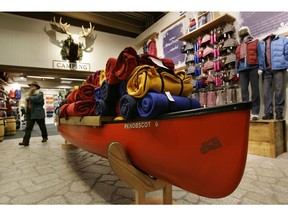 FILE- In this Nov. 28, 2008, file photo, a shopper passes a canoe displayed with fleece sleeping bags at the L.L. Bean flagship retail store in Freeport, Maine. L.L. Bean has launched a dedicated Canadian website that smooths out duties and currency fluctuations.