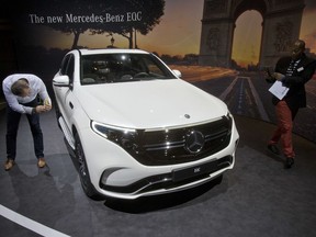 Media people look at a Mercedes-Benz EQC, electric luxury SUV during a media presentation on the eve of Paris Auto Show in Paris, France, Monday, Oct. 1, 2018. Doubts about diesel, Brexit, trade worries, tighter emissions controls. Those are the challenges that will be on the minds of auto executives when they gather this week ahead of the Paris Motor Show at the Porte de Versailles exhibition center.