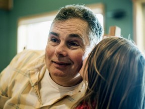 FILE - In this Jan. 12, 2017, file photo, William Putman II gets a kiss on the cheek from his daughter at the Putman home in Caseville Township, Mich. A federal gun charge against Putman, who appeared with his family as the central figure in the TLC show "Meet the Putmans," has been dismissed.