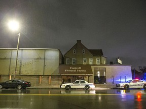 Detroit Police vehicles are parked outside of the Cantrell Funeral Home in Detroit on Friday, Oct. 12, 2018. Police said an anonymously written letter led inspectors to find the decomposed remains of 11 infants hidden in a ceiling compartment of the shuttered funeral home.