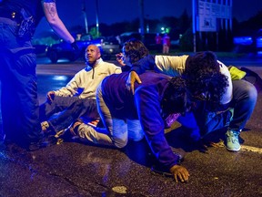 People gather to tend to protesters after several people were hospitalized when a truck collided with into protesters calling for the right to form unions Tuesday, Oct. 2, 2018, in Flint, Mich. Police said the collision appears to be an accident.