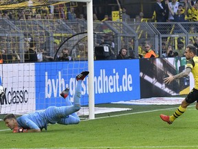 Dortmund's Paco Alcacer, right, scores his side`s first goal against Augsburg goalkeeper Andreas Luthe, left, during the German Bundesliga soccer match between Borussia Dortmund and FC Augsburg in Dortmund, Germany, Saturday, Oct. 6, 2018.