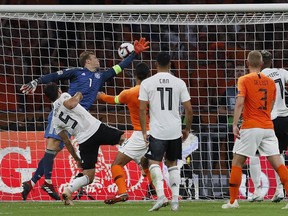 Netherland's Virgil Van Dijk, center, heads the opening goal against Germany's keeper Manuel Neuer during the UEFA Nations League soccer match between The Netherlands and Germany at the Johan Cruyff ArenA in Amsterdam, Saturday, Oct. 13, 2018.