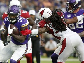 Minnesota Vikings running back Latavius Murray (25) breaks a tackle by Arizona Cardinals defensive back Tre Boston, right, during a 21-yard touchdown run in the first half of an NFL football game, Sunday, Oct. 14, 2018, in Minneapolis.