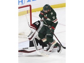 Minnesota Wild's Zach Parise, right, jumps clear and into Arizona Coyotes' goalie Darcy Kuemper to make way for a shot in the first period of an NHL hockey game Tuesday, Oct. 16, 2018, in St. Paul, Minn.