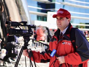 In this Thursday, Oct. 4, 2018 photo, KTTC-TV multimedia journalist James Bunner wears a "Make America Great Again" hat while interviewing people waiting to see President Donald Trump in Rochester, Minn. News Director Noel Sederstrom says the station does not allow staff members to cover stories while wearing apparel from political campaigns. Sederstrom says Bunner was fired.